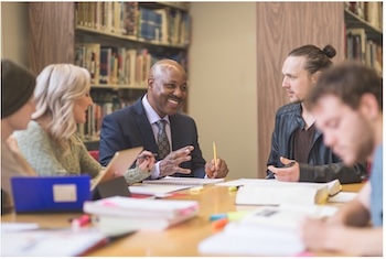 Adults collaborating around a table in a library