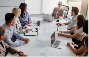 Group of adults sitting around a conference table having a meeting