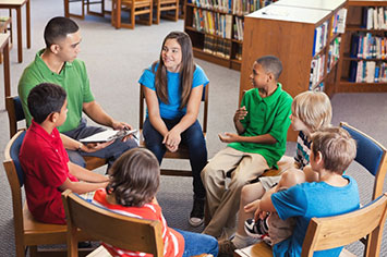 Kids sitting in a circle.