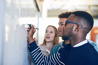 A person writing something on a whiteboard.