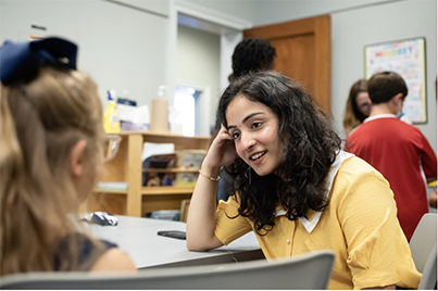 A teacher talking to a student in a classroom