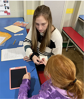 A teacher working with a student in the classroom.