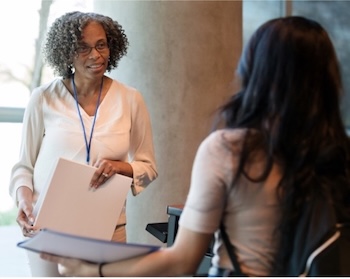 Older woman speaking to younger woman in hallway